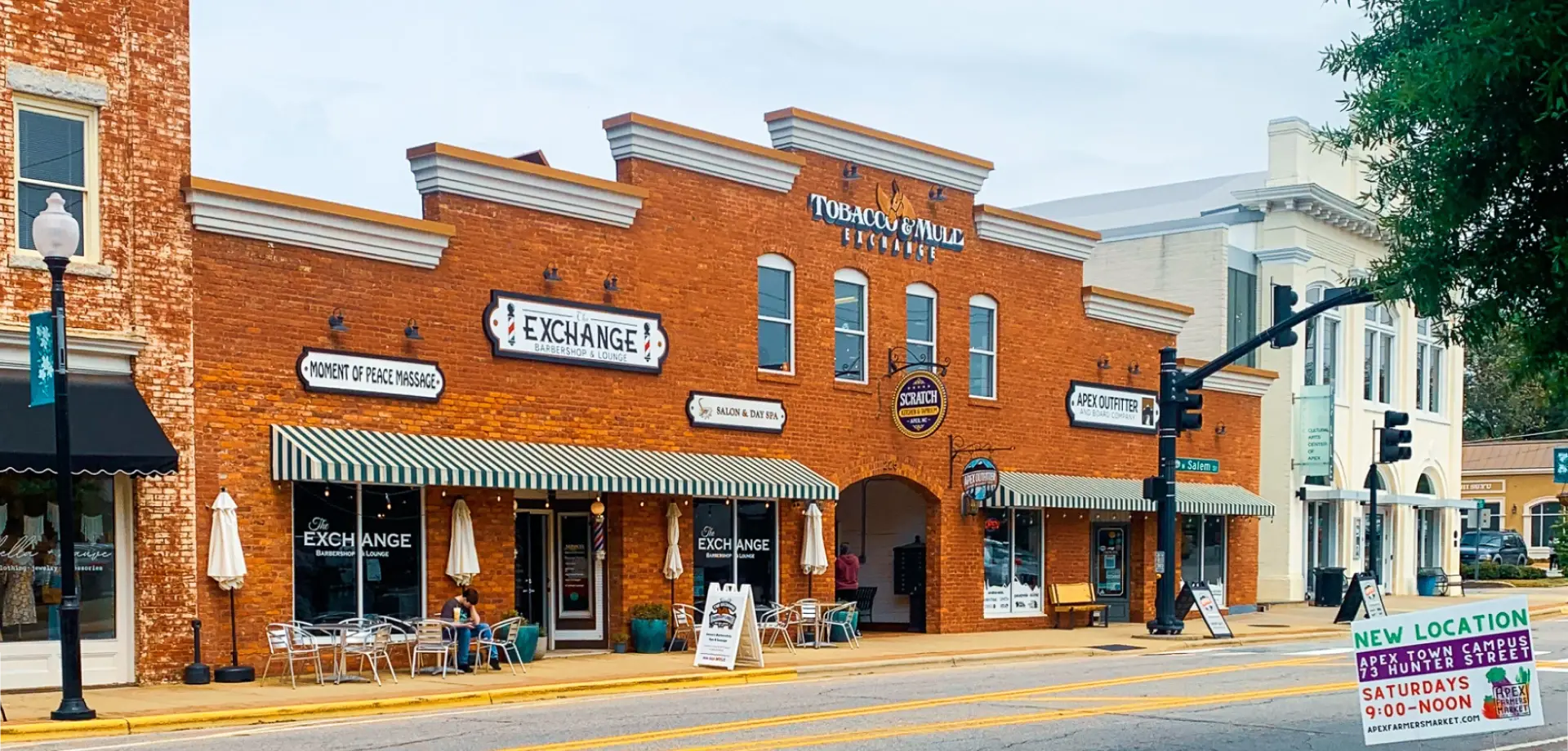 Historic brick storefronts with shops and cafés along a small-town street