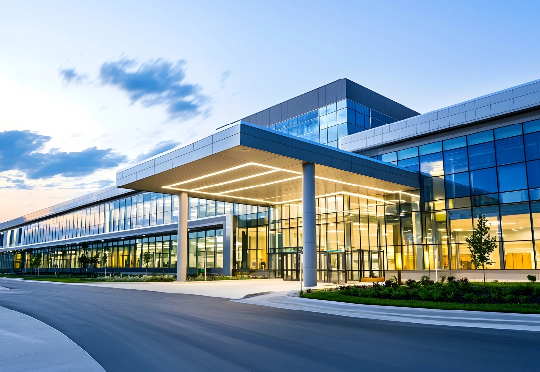 Modern commercial building with glass exterior and bright lighting at dusk