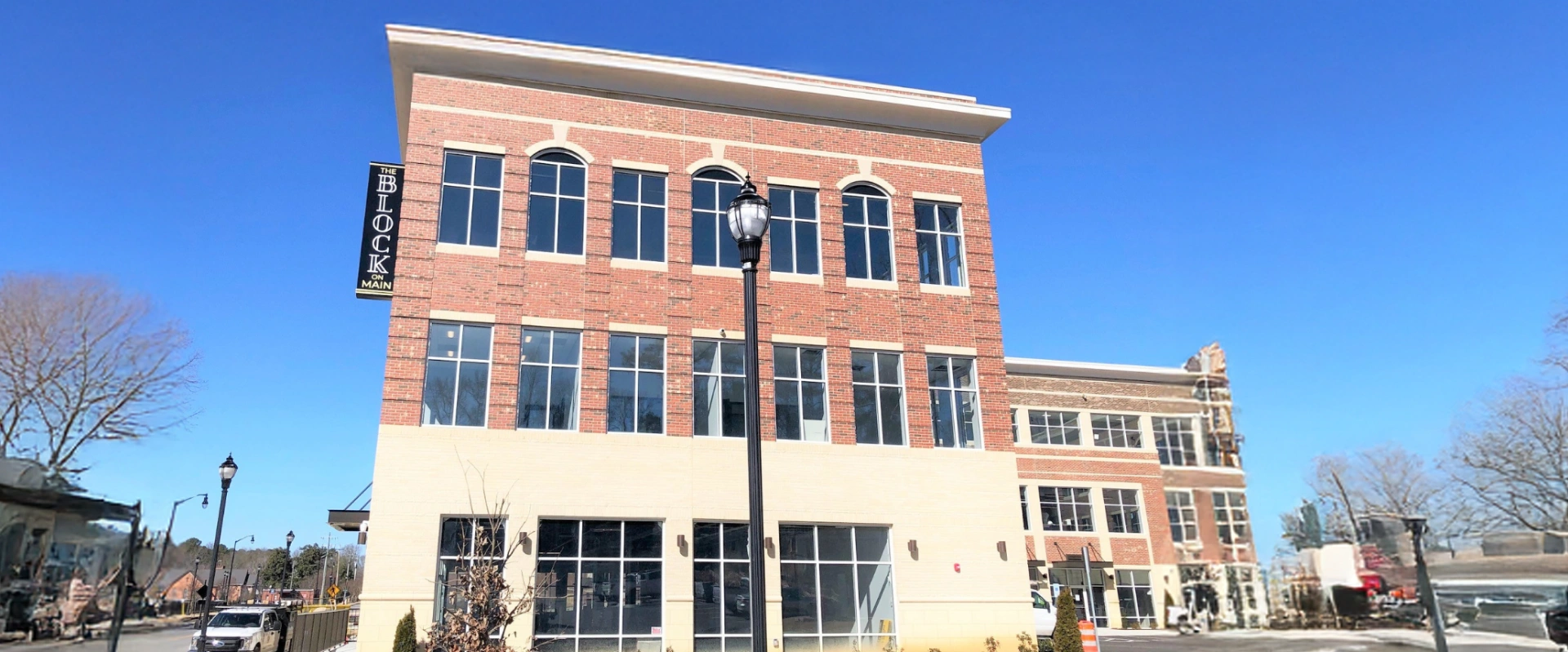 Three-story brick commercial building under a clear blue sky