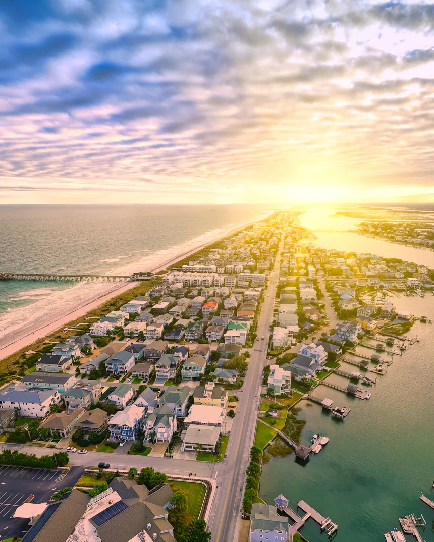 Aerial view of a coastal Wilmington neighborhood between the Atlantic Ocean and the Intracoastal Waterway at sunset